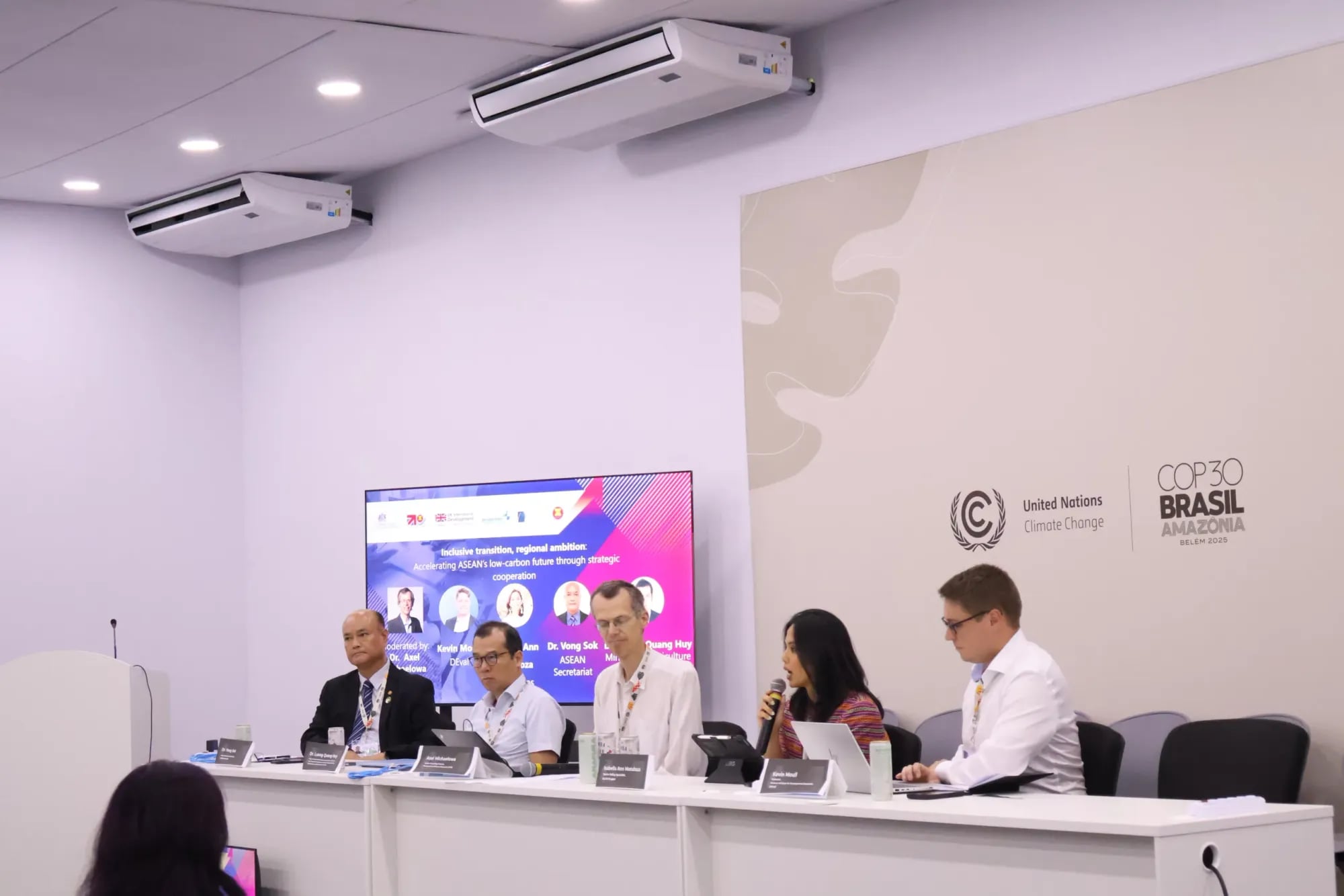 Panellists at an expert panel discussion during the COP30 climate conference in Belém, one speaking into a microphone
